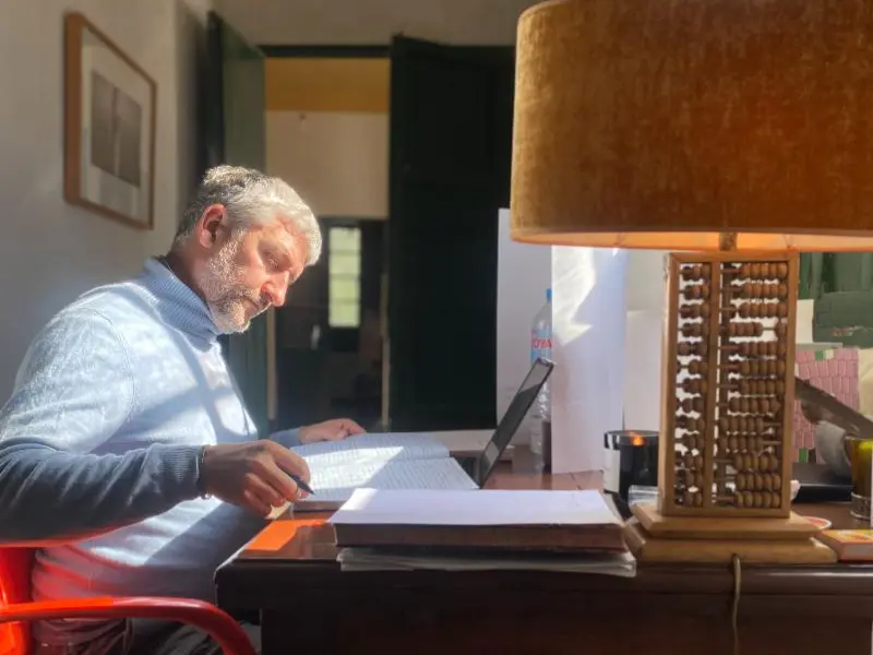Manni writing at his desk